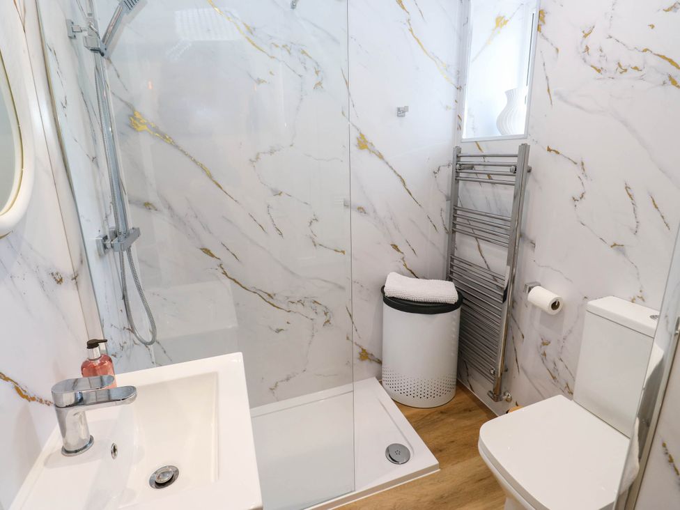 A bathroom with shower, basin, and toilet at Brodie Cottage in Brighouse