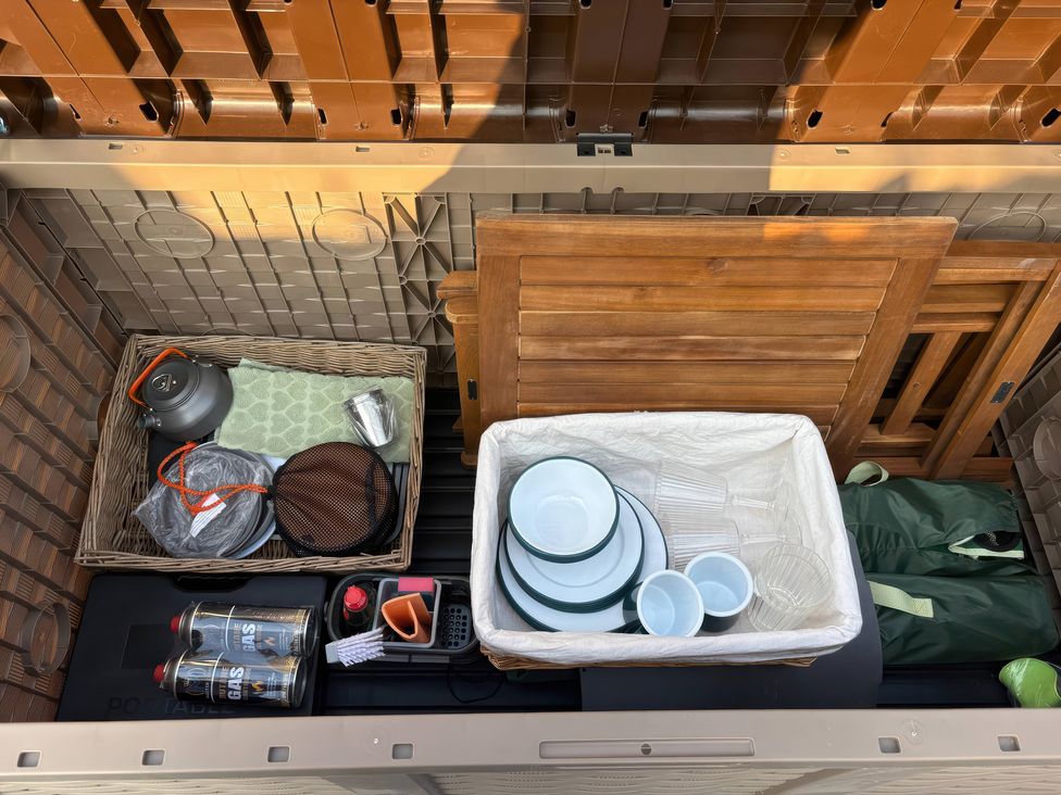 A storage box containing kitchen items and utensils at Darn Mawr