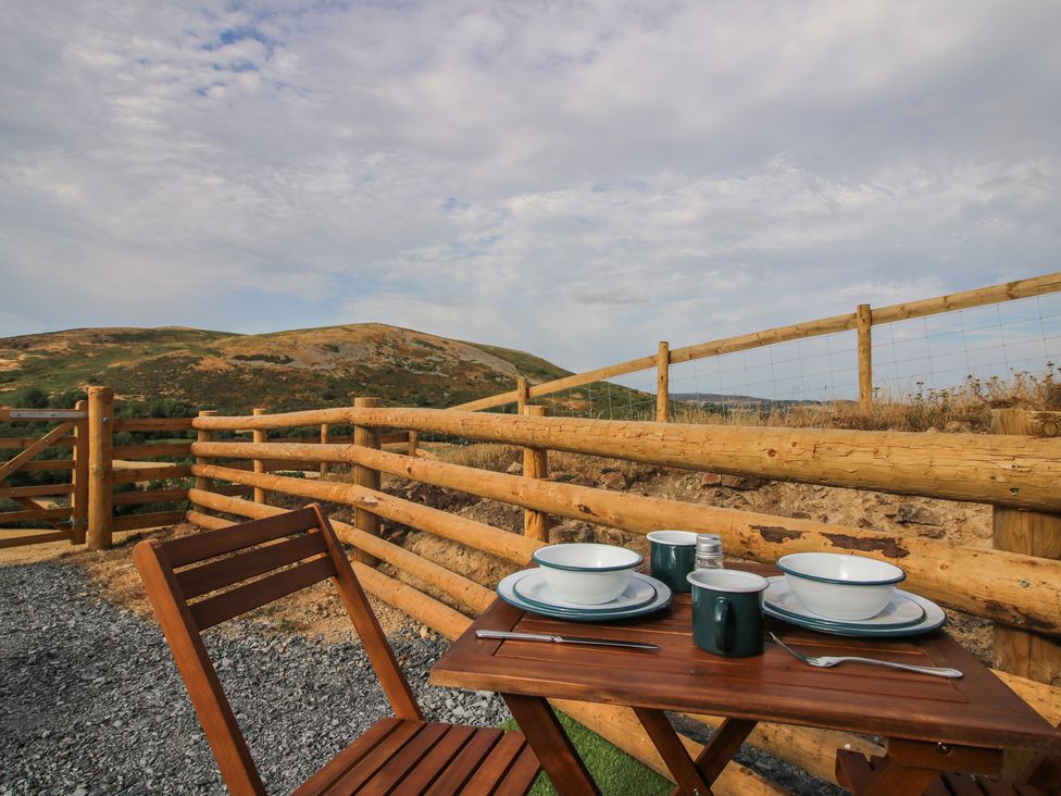 An outdoor dining area with table and plates at Darn Mawr 