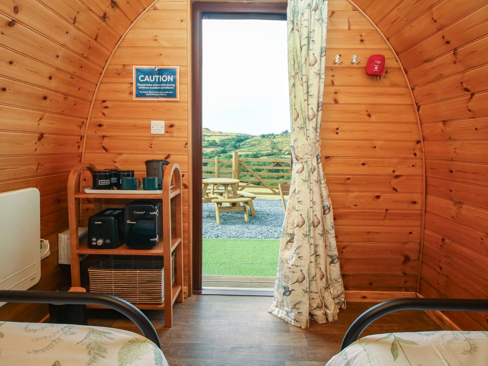 An indoor view of a pod with a shelf and doorway at Darn Mawr 