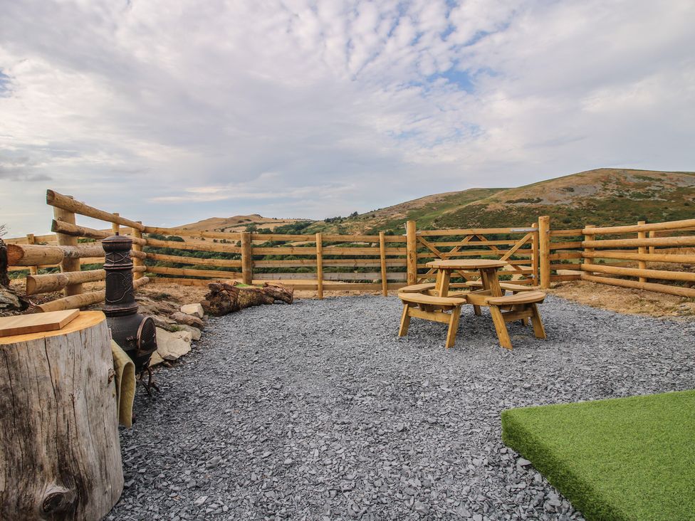 An outdoor area with a wooden table and benches at Darn Mawr in 