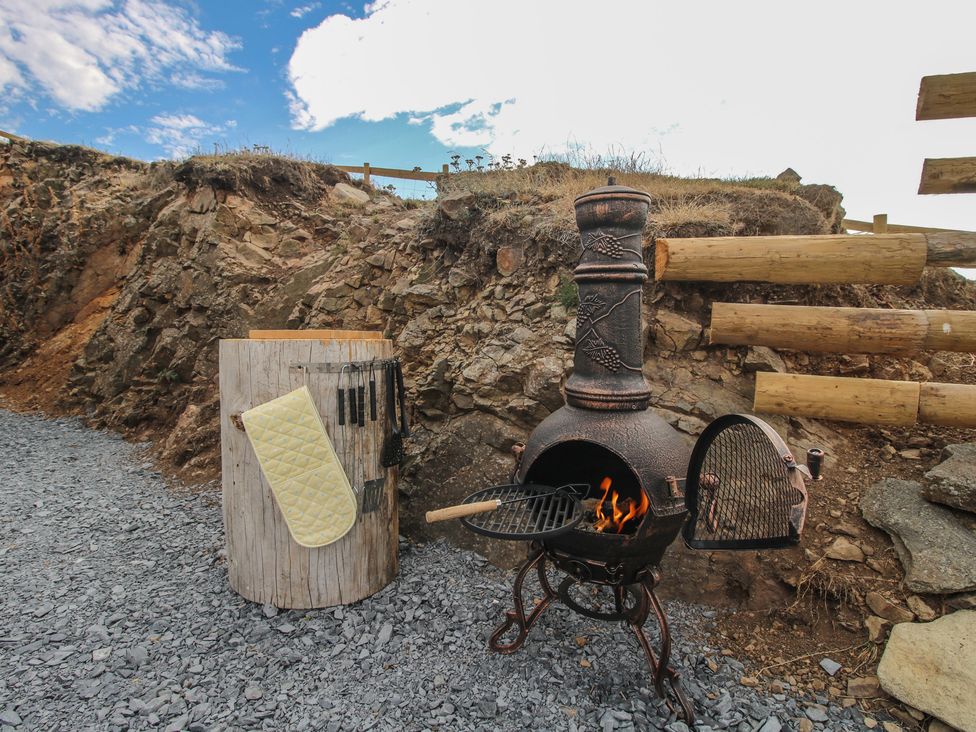 An outdoor grill and cooking area with a stove and utensils at Darn Mawr 