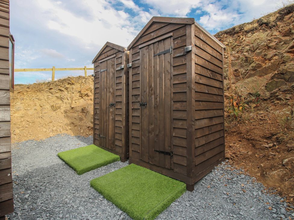 Wooden sheds on gravel in an outdoor area at Darn Mawr 