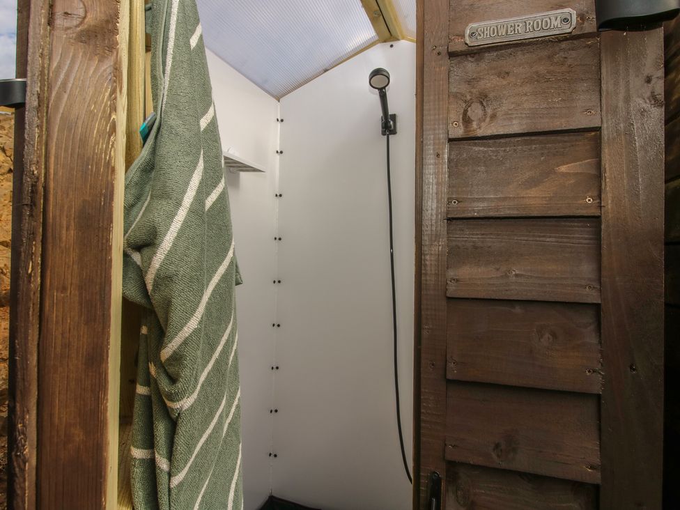 A shower room with a towel hanging and shower head at Darn Mawr 