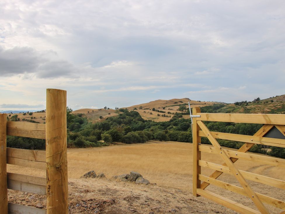 A view of hills and a wooden gate at Darn Mawr in 