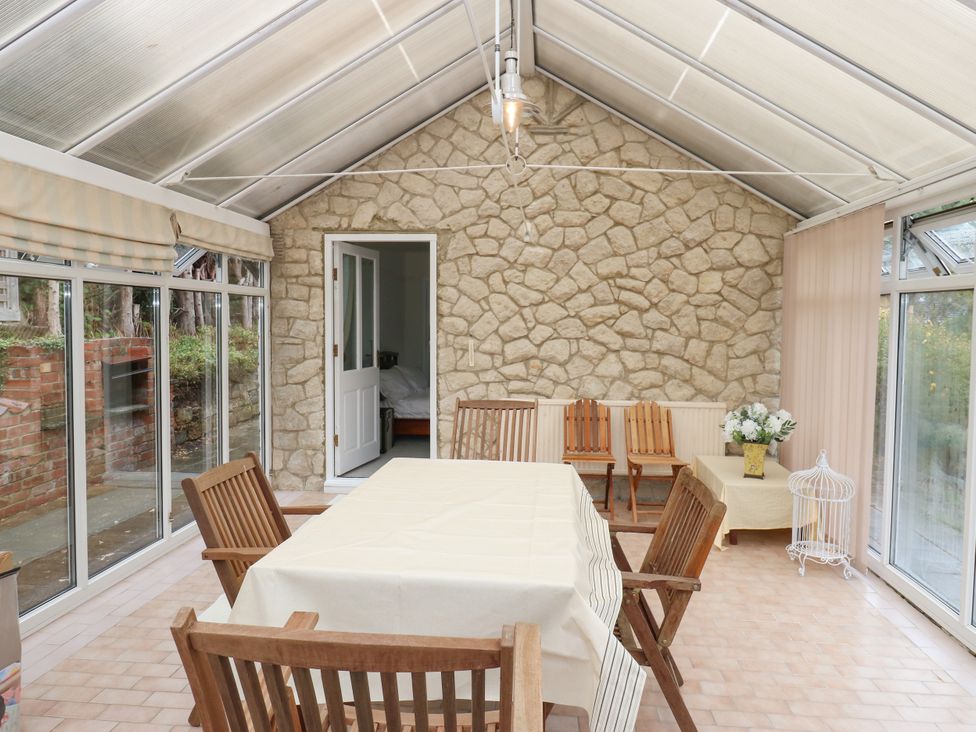 A conservatory with a table and chairs at 12 The Dell in Bardsey near Wetherby