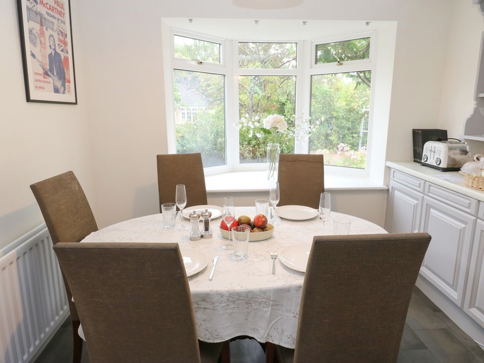 A dining room with a round table set for a meal at 12 The Dell in Bardsey near Wetherby