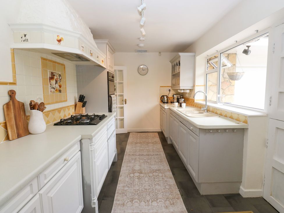 A kitchen with cabinets, stove, sink, and appliances at 12 The Dell in Bardsey near Wetherby