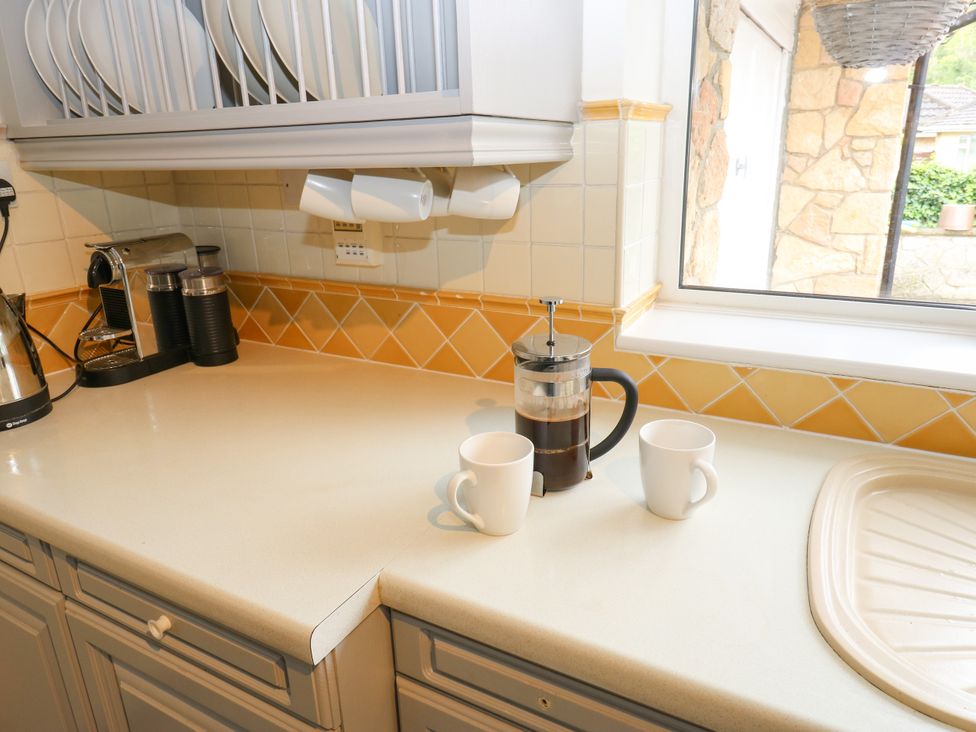 A kitchen countertop with a kettle, coffee maker, French press, and coffee cups at 12 The Dell, Bardsey near Wetherby