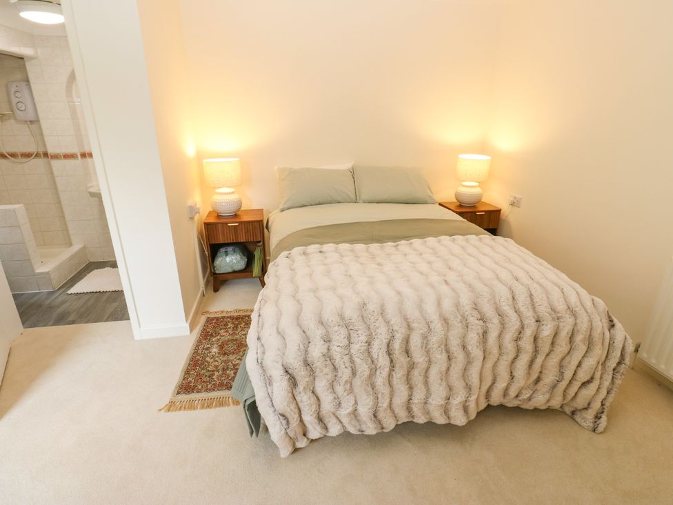 A bedroom with a bed and nightstand at 12 The Dell in Bardsey near Wetherby