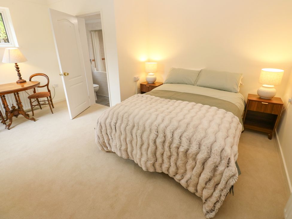 A bedroom with a bed and nightstands at 12 The Dell Bardsey near Wetherby