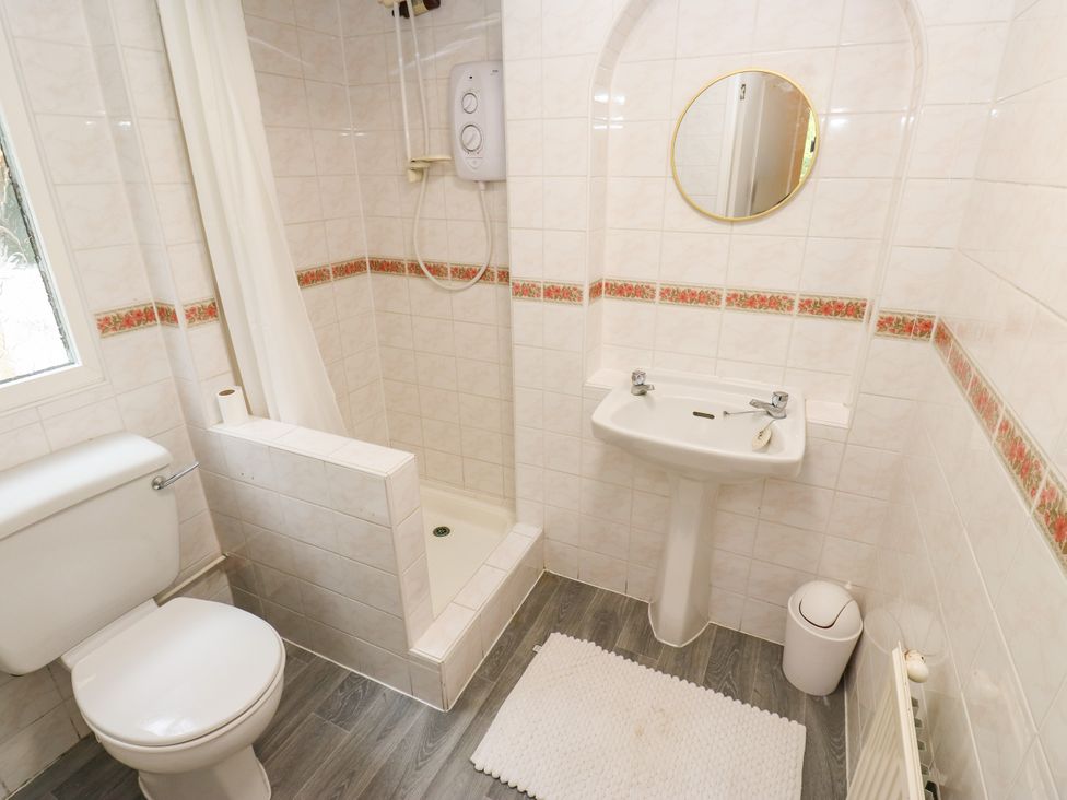 A bathroom with a shower, sink, and toilet at 12 The Dell in Bardsey near Wetherby