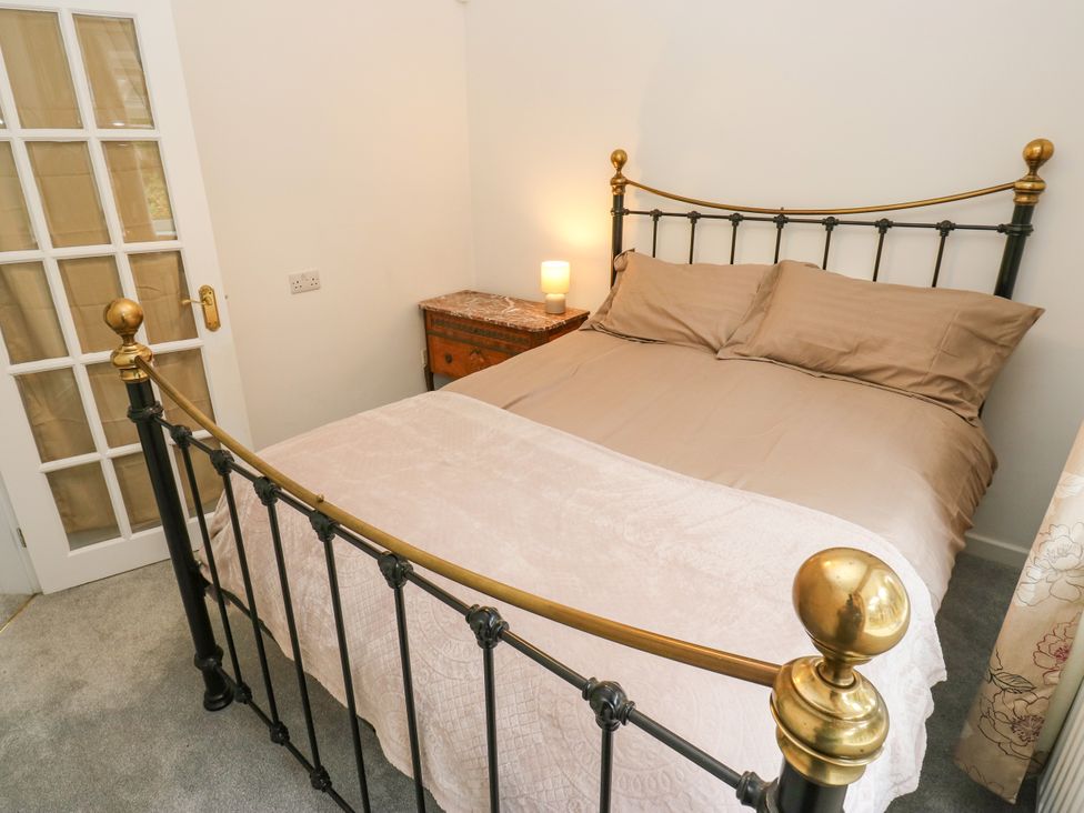 A bedroom with a bed and a lamp at 12 The Dell in Bardsey near Wetherby
