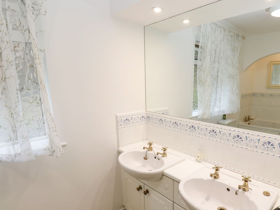 A bathroom with double sink and mirror at 12 The Dell, Bardsey near Wetherby