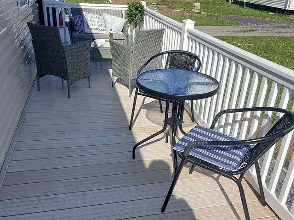 An outdoor seating area with chairs and a table at Demelza (B34) Seven Bays Holiday Park, Padstow