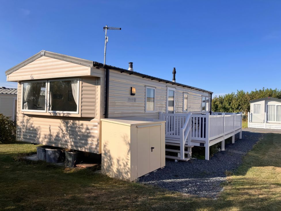 A mobile home with a deck and shed at Demelza (B34) Seven Bays Holiday Park Padstow