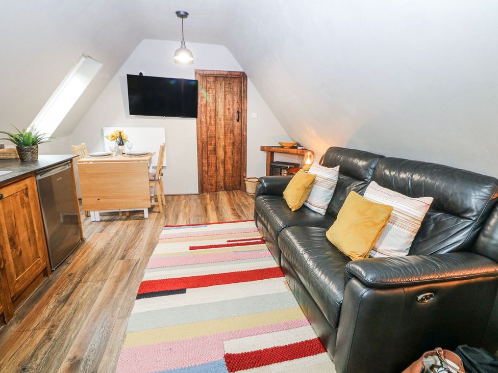 A living room with a sofa and dining area at Little Mill in Ashover