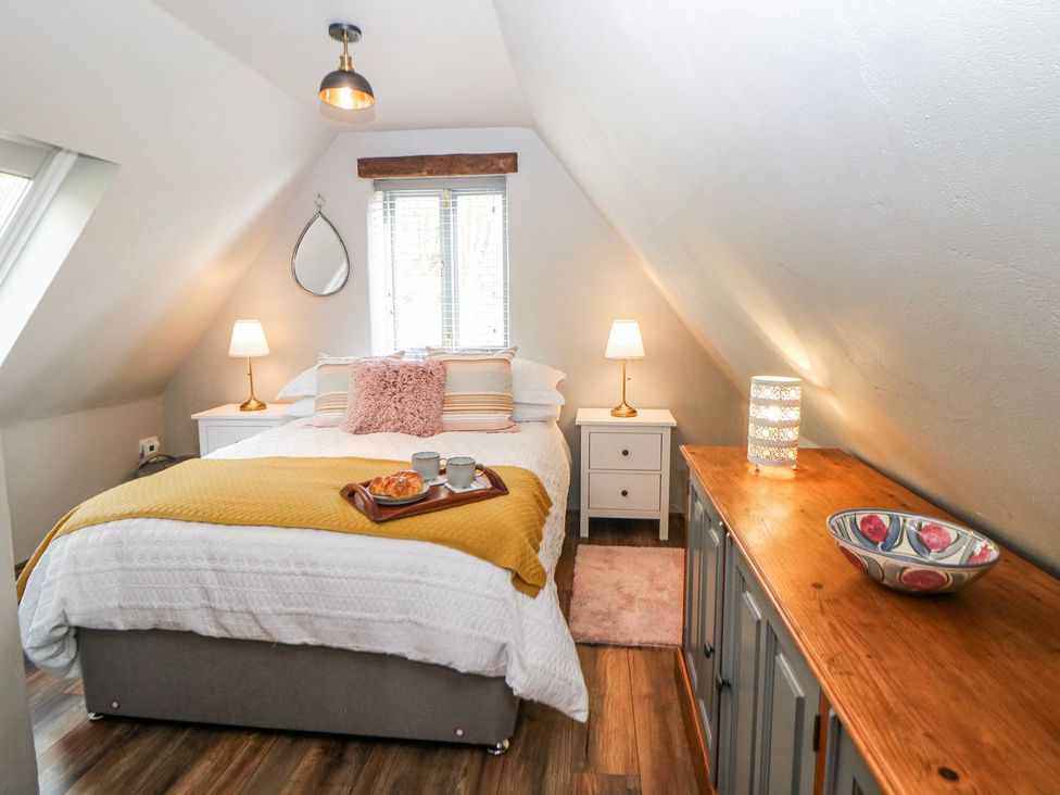 A bedroom with a bed and nightstand at Little Mill in Ashover