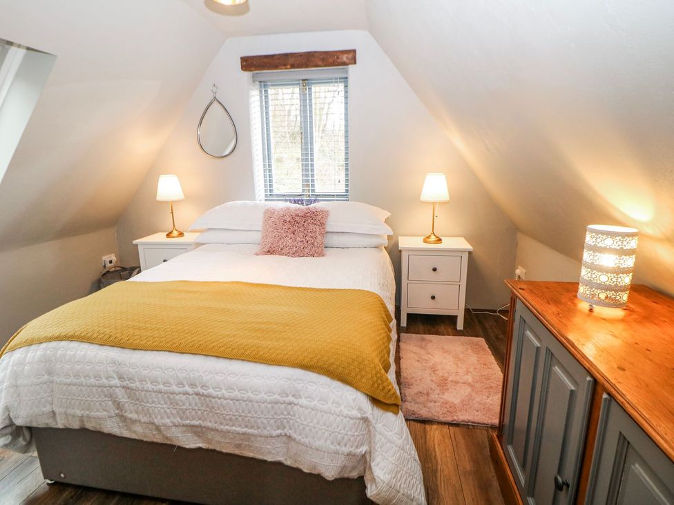 A bedroom with a bed and bedside tables at Little Mill in Ashover