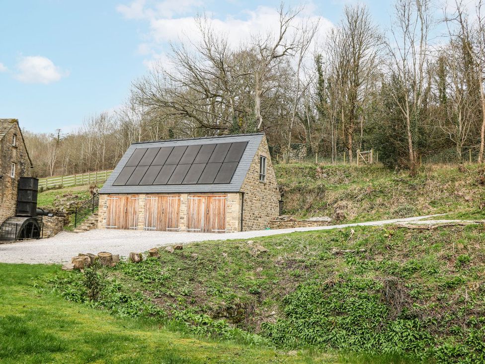 A building with wooden doors and a pathway at Little Mill in Ashover