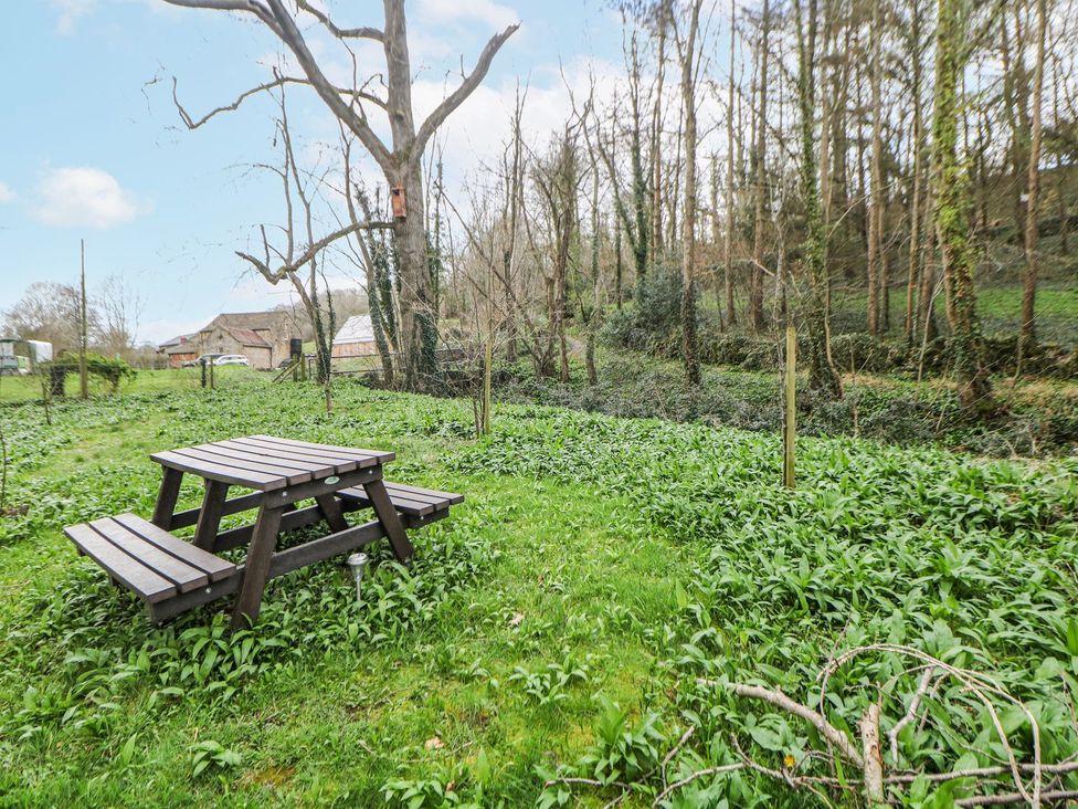 A garden with a picnic table and trees at Little Mill in Ashover