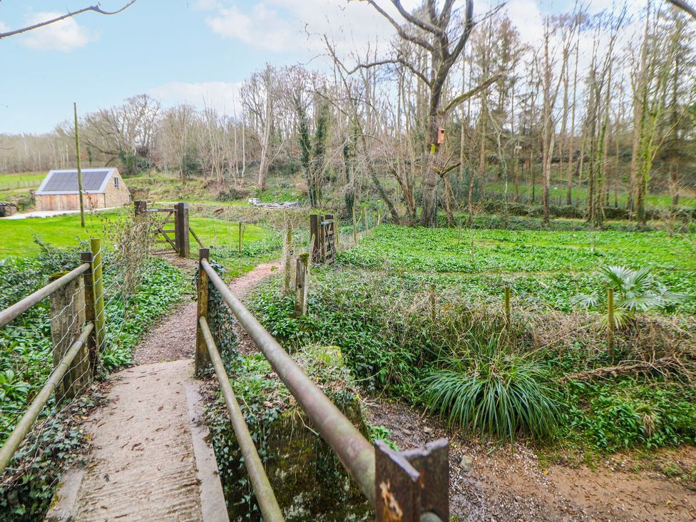 A pathway leading to a gate with a building and trees at Little Mill Ashover