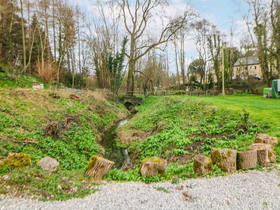 A garden with a stream and trees at Little Mill in Ashover