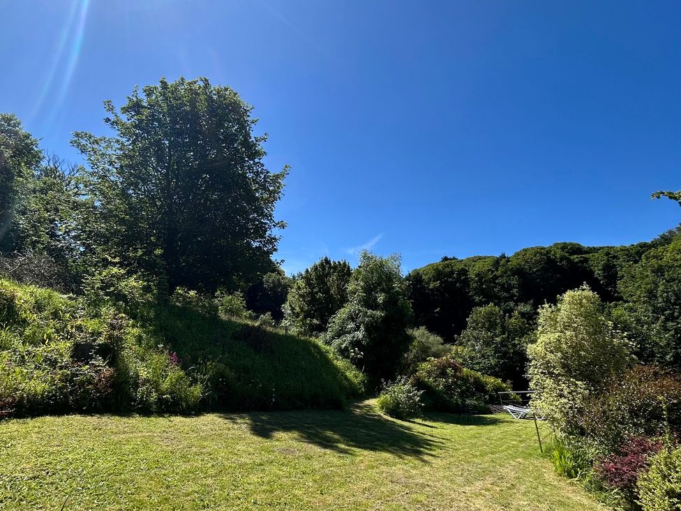 A garden with trees and green grass at The Old Forge Bickerton near East Prawle