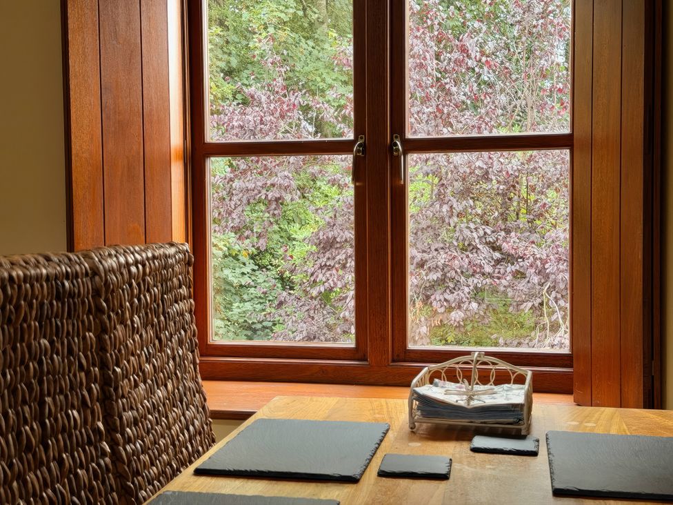 A dining room with a table and a window at The Old Forge in Hallsands
