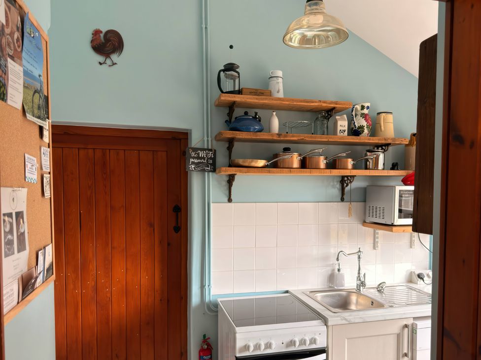 A kitchen with shelves and appliances at The Old Forge Hallsands