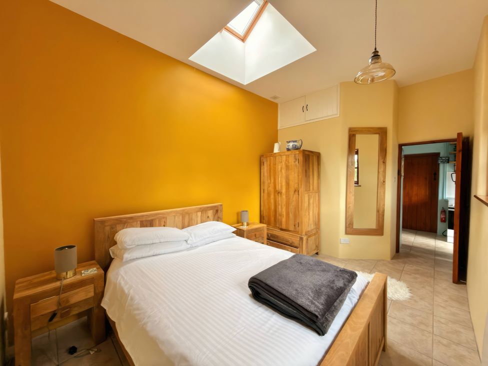A bedroom with a bed and a wardrobe at The Old Forge in Hallsands