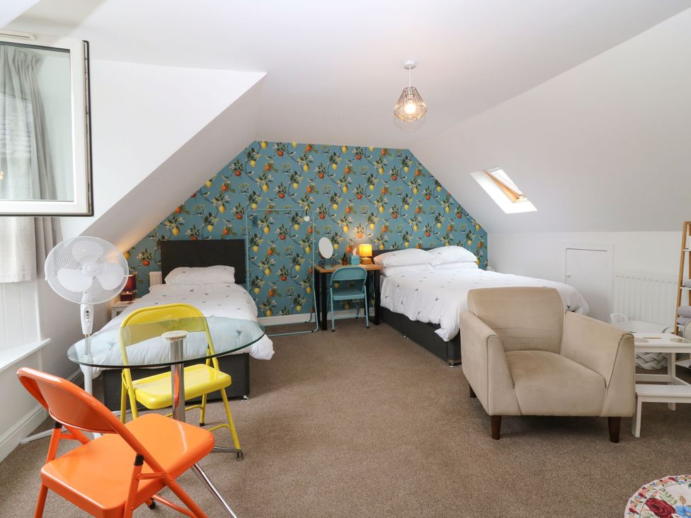 A bedroom with two beds and a table at Hill View Studio in Hawick