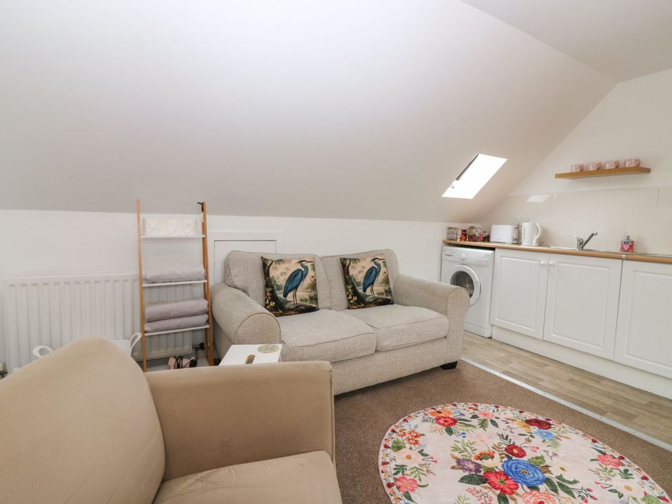 A studio with a sofa and washing machine at Hill View Studio in Hawick