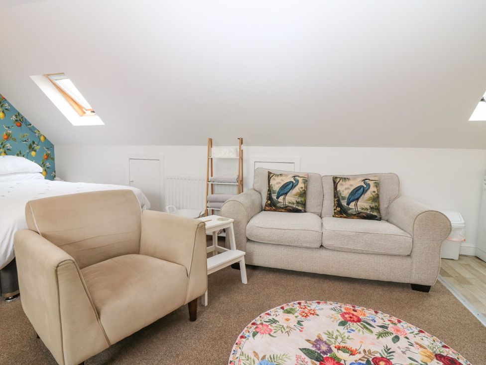 A bedroom with a sofa and armchair at Hill View Studio in Hawick