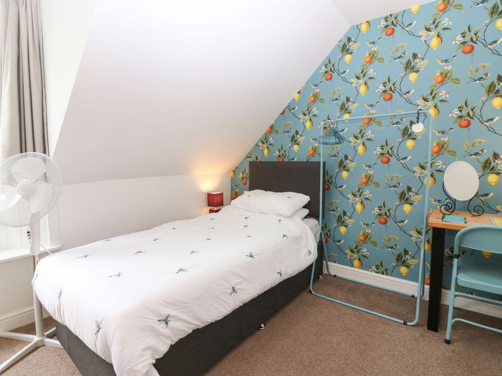 A bedroom with a bed, fan, and dresser at Hill View Studio in Hawick