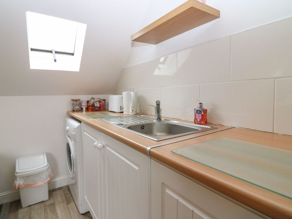 A kitchen with a sink and washing machine at Hill View Studio in Hawick
