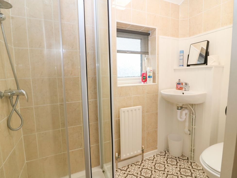A bathroom with a shower, toilet, and sink at Hill View Studio, Hawick