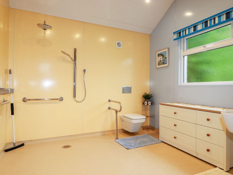 A bathroom with a shower, toilet, and sink at Brambleside Lodge, Truro
