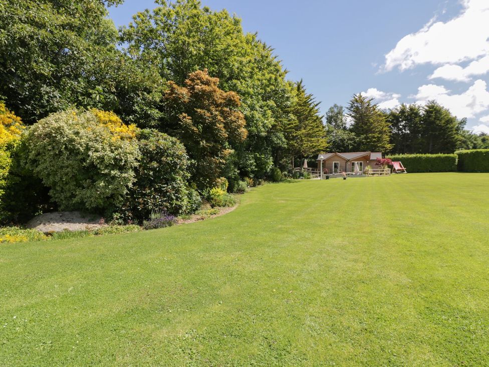 A garden with a house and lawn at Brambleside Lodge in Truro