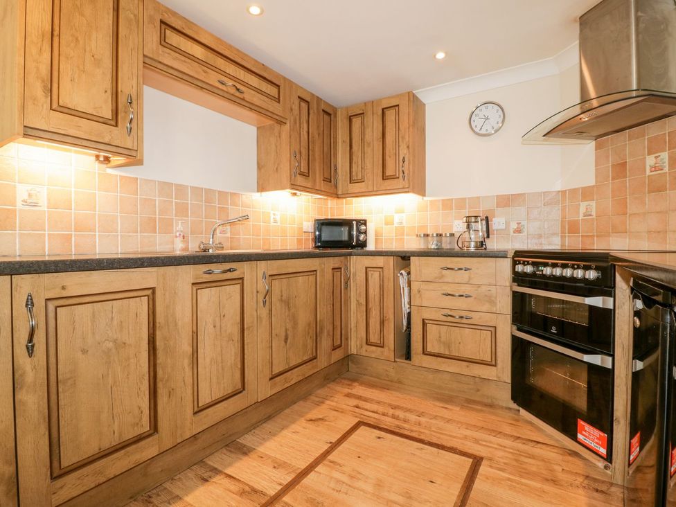 A kitchen with wooden cabinets and appliances at Lower Brambleside in Truro