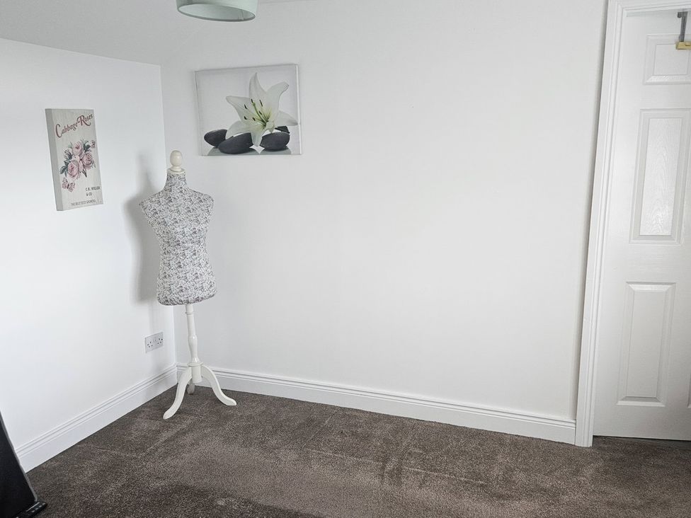 A room with a mannequin, wall art, and a door at Mourne Mountains View in Dunmurry