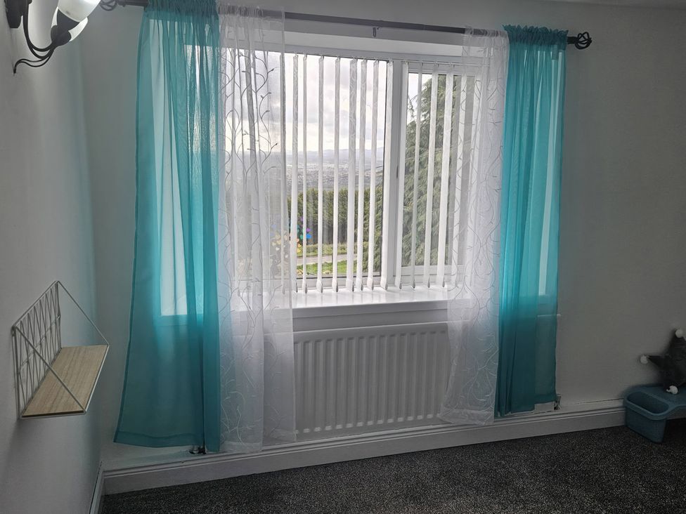 A bedroom with a window and curtains at Mourne Mountains View Dunmurry