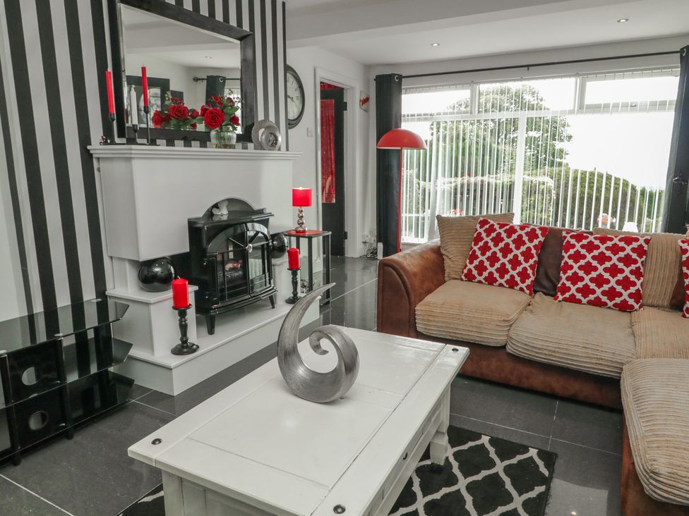 A living room with a fireplace and sofa at Mourne Mountains View in Dunmurry