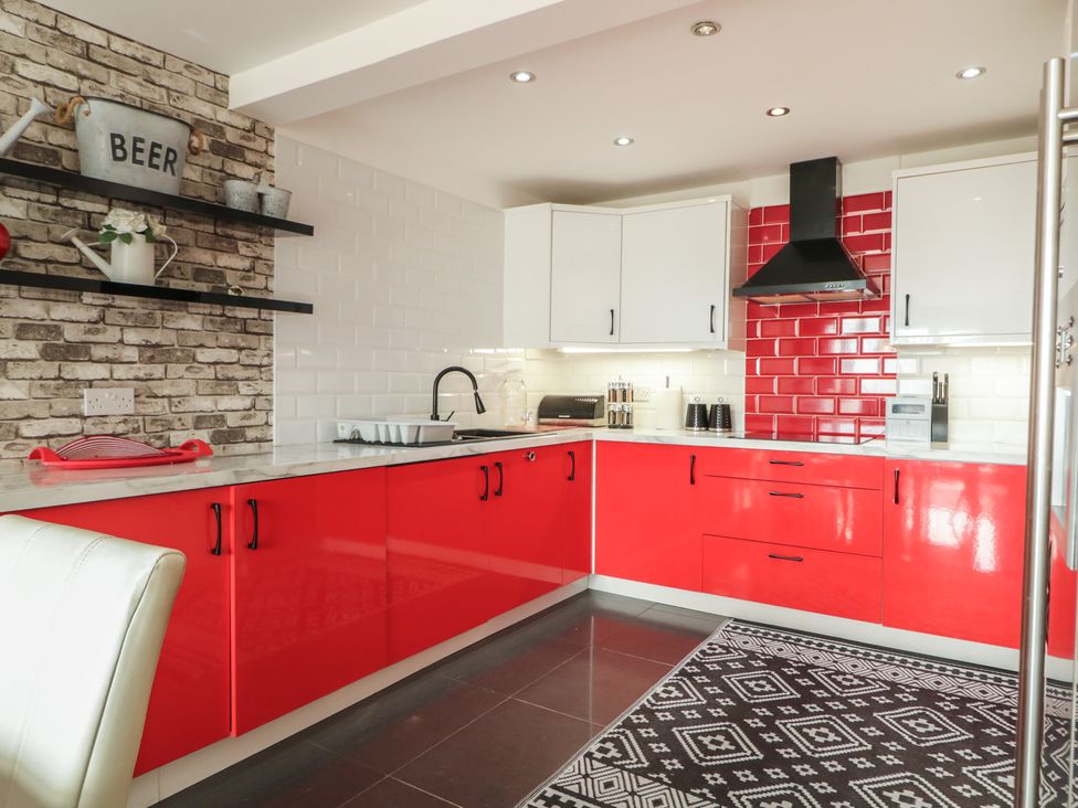 A kitchen with red cabinets and a sink at Mourne Mountains View in Dunmurry