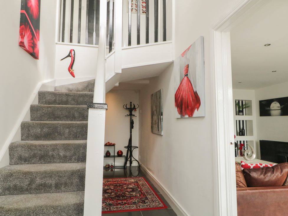 A hallway with stairs and a coat rack at Mourne Mountains View in Dunmurry