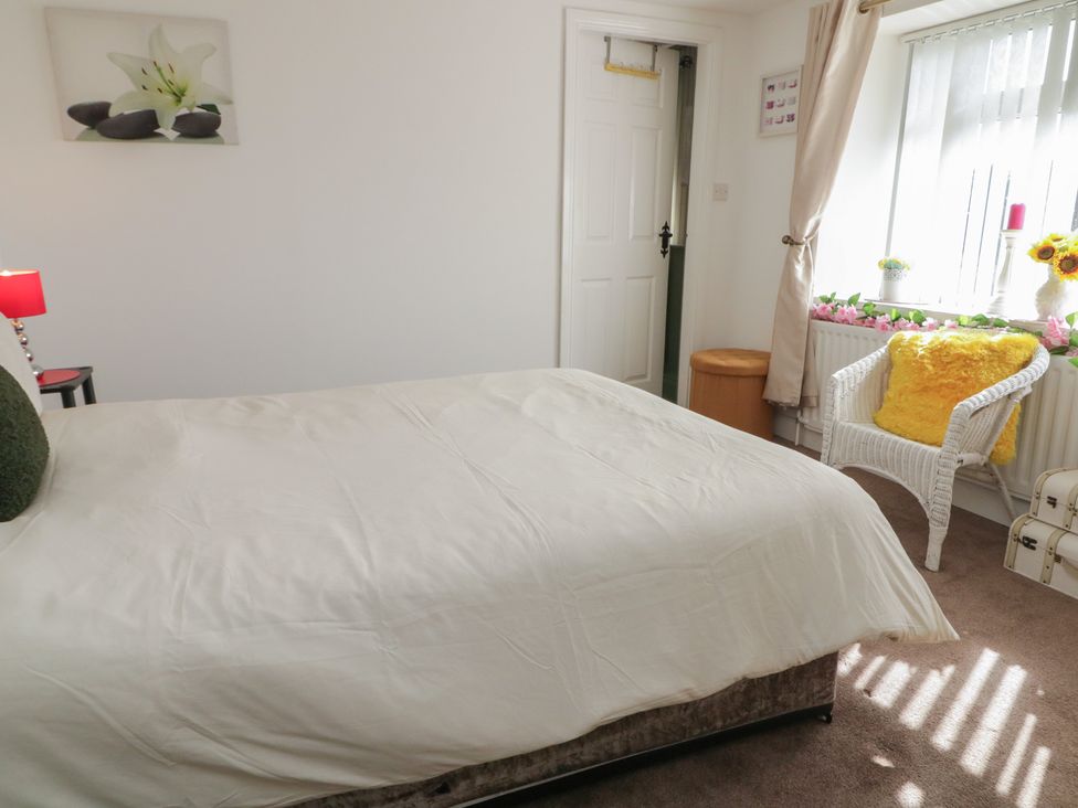 A bedroom with a bed, lamp, and a chair at Mourne Mountains View in Dunmurry