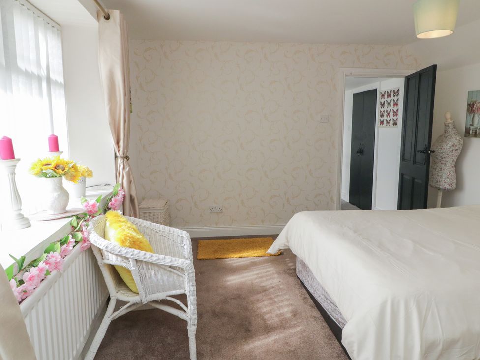 A bedroom with a bed, window, and wicker chair at Mourne Mountains View Dunmurry