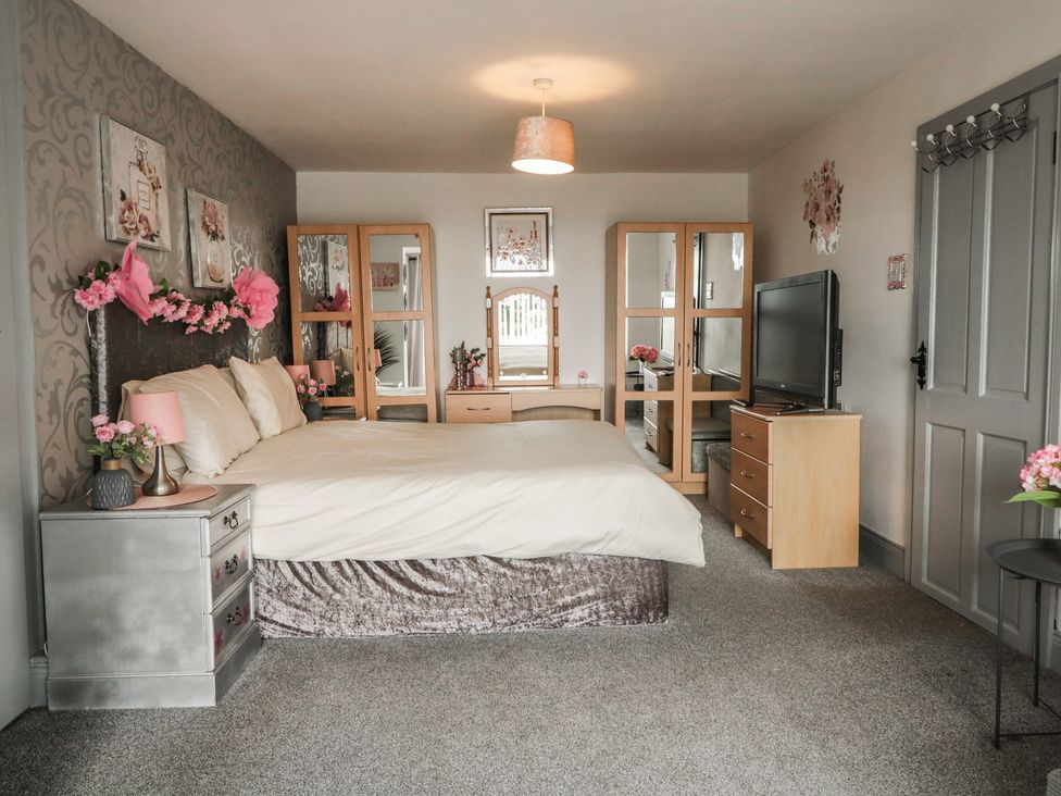 A bedroom with a bed and wardrobe at Mourne Mountains View in Dunmurry
