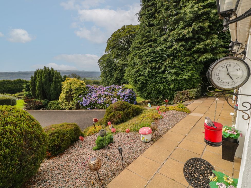 A garden with flowers and a clock at Mourne Mountains View in Dunmurry