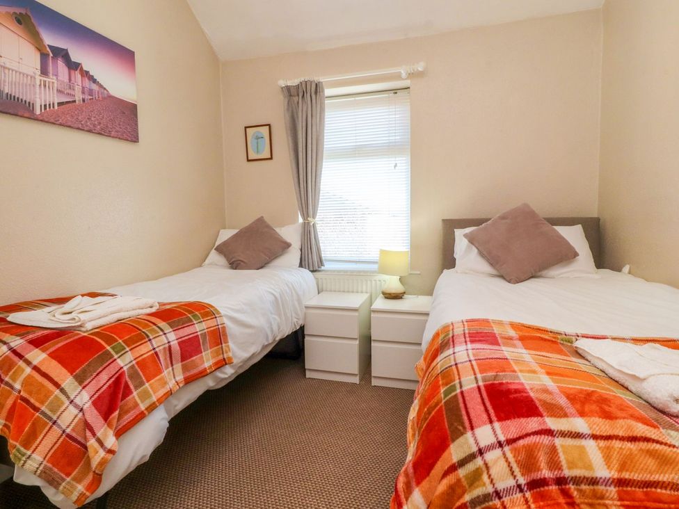 A bedroom with two single beds and a nightstand at Lytham House in Lytham St. Annes